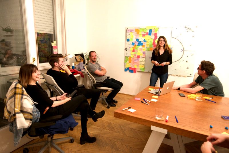 Starship Canvas workshop at Exalt Interactive &ndash; team discussing sticky notes on the canvas